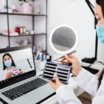 Jovem profissional de beleza assistindo videoaula de extensão de cílios com kit completo em estúdio